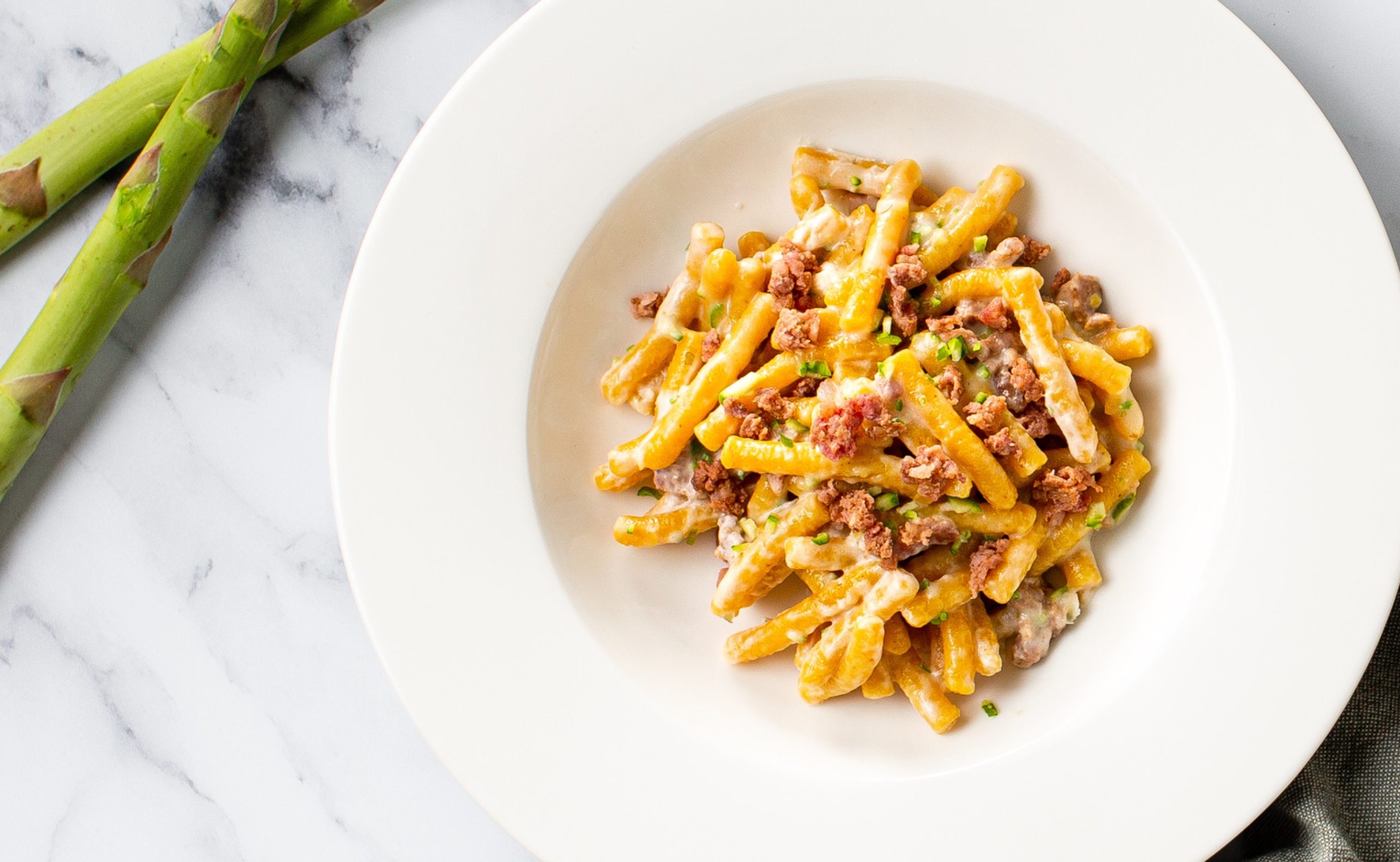 Passatelli con asparagi, caprino e salsiccia